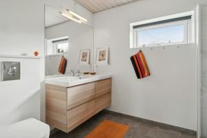 a bathroom with a sink and a window at Holiday Home With Lake In Mols Bjerge in Knebel