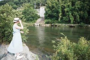 大淀町にある10人宿泊可 添い寝無料 1日1組限定で開放感のある90平米 吉野山天川村40分 奈良大阪1時間 駅から徒歩5分 家主居住型 大淀桜庵の川のそばの岩の上に立っている女性