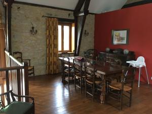 a dining room with a wooden table and chairs at La Grange Du Noyer in Cornac
