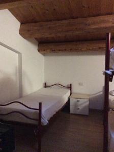 1 dormitorio con 2 camas y techo de madera en Il mondo roverso, en Feltre