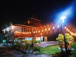 un bâtiment avec un éclairage de rue devant lui la nuit dans l'établissement ในสวนรัตนมณีรีสอร์ท, à Ban Pak Khlong