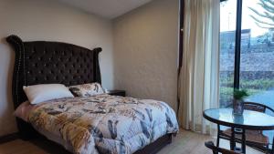 YarabambaにあるCasa de Campo Yarabambaのベッドとテーブルと窓のある寝室