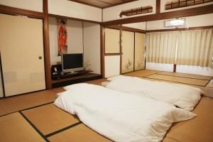 a room with two beds and a flat screen tv at 8人宿泊可 子供添い寝無料 1日1組限定で開放感のある90平米 吉野山天川村40分 奈良大阪1時間 駅から徒歩5分 家主居住型 大淀桜庵 in Oyodo +141 photos
