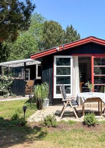 a house with a bed and a chair in front of it at Family-Friendly Holiday Home Near Skærby Beach in Nykøbing Sjælland