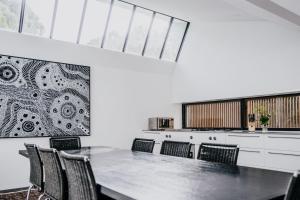 a dining room with a long table and chairs at Alkina Lodge Milu in Wattle Hill