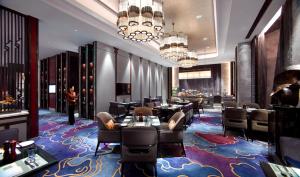 呼和浩特的住宿－呼和浩特富力萬達文華酒店，餐厅铺有色彩缤纷的地毯,配有桌椅