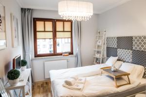 a small bedroom with a bed and a chandelier at 3EM Apartment Sopot in Sopot