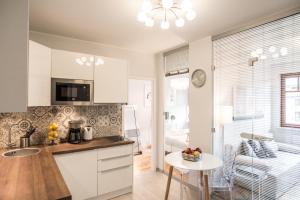 a kitchen with white cabinets and a table at 3EM Apartment Sopot in Sopot