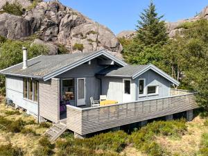 a small house on the side of a hill at Traditional Cabin With Sea View In Jæren in Sirevåg