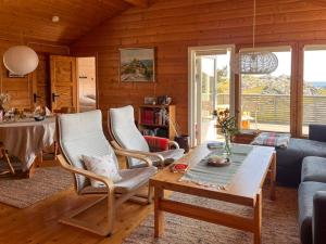 a living room with a table and a couch at Traditional Cabin With Sea View In Jæren in Sirevåg +23 photos