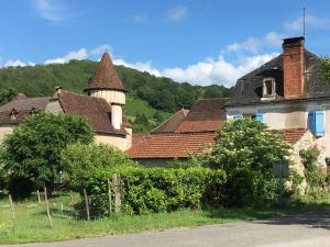 a group of houses with a mountain in the background at La Grange Du Noyer in Cornac