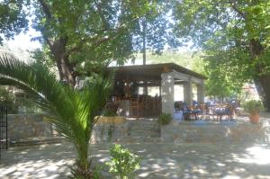 a pavilion with tables and chairs in a garden at Hotel Zachos in Troulos