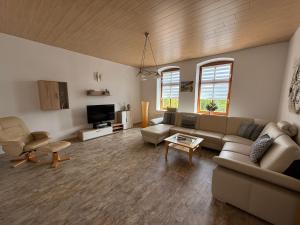 a living room with a couch and a tv at Fewo zum Klosterhof OG 2 in Nienhagen