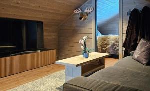 a living room with a couch and a table with a tv at New Cabin With Panoramic Views Of Lake Osen in Hektner