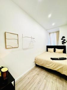 a white bedroom with a bed and a wooden floor at Elegant 5-BR shared Home , Ideal for Groups & Families in Vienna