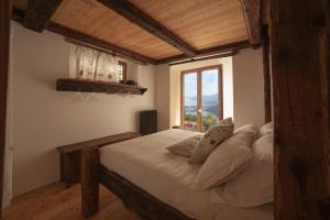 a bedroom with a large bed with a large window at Magica Vercio in Mergozzo
