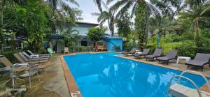 a swimming pool with chairs and a house at Sabai Resort in Ao Nang Beach