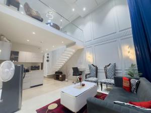 グルガオンにあるKiki Stay - Loft Studio Apartmentのソファとテーブルのあるリビングルーム