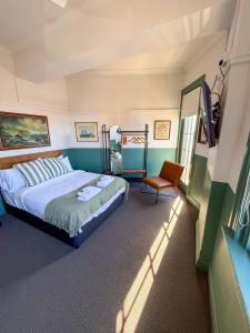 a bedroom with a bed and a chair in it at Courthouse Hotel in Sydney