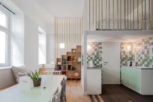 a kitchen and living room with a white table in a room at grätzlhotel Meidlinger Markt in Vienna
