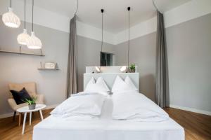 a bedroom with a white bed with white pillows at grätzlhotel Meidlinger Markt in Vienna