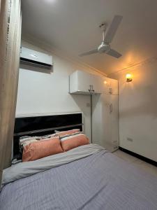 Un dormitorio con una cama y un ventilador de techo. en BnV homes, en Dar es Salaam 16 fotos más
