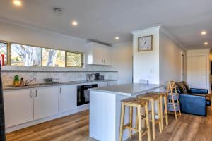 a kitchen with white cabinets and bar stools at 42 Old Murbko Road in Morgan