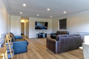 a living room with leather furniture and a flat screen tv at 42 Old Murbko Road in Morgan