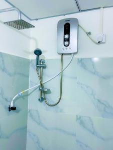 a bathroom with a shower with a phone on the wall at Sigiri Rew Haven in Sigiriya