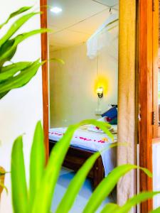 Cama pequeña en habitación con planta en Sigiri Rew Home Stay, en Sigiriya