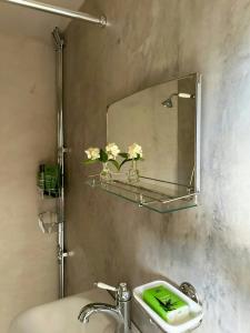 une salle de bain avec un lavabo et un miroir au mur dans l'établissement Historic Cottages At The 18Th Century Vicarage, à Varmlands Nysater 32 autres photos