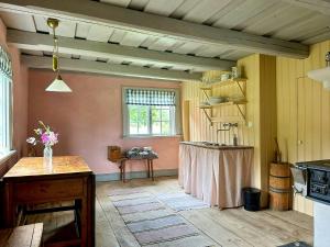 - une cuisine avec une table au milieu d'une pièce dans l'établissement Historic Cottages At The 18Th Century Vicarage, à Varmlands Nysater