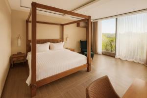 a bedroom with a canopy bed and a large window at Ducat Living in Canggu +65 photos