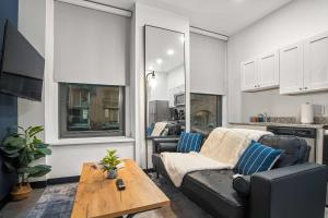 un soggiorno con un divano e un tavolo di CozySuites Stunning 1BR in Downtown Pitts 39 a Pittsburgh