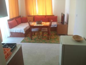 een woonkamer met een tafel en een bank bij Apartments in Villa Rouge in Sozopol