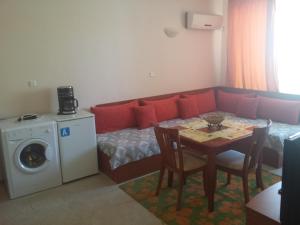 a living room with a couch and a table with a washing machine at Apartments in Villa Rouge in Sozopol