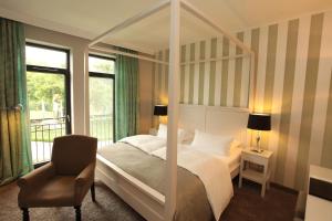克里維茨的住宿－巴斯歇斯特城​​堡酒店，一间卧室配有一张天蓬床和一把椅子