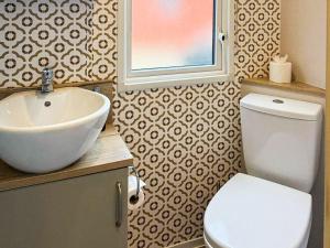 a bathroom with a white sink and a toilet at Lodge 58 in Aviemore
