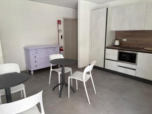a kitchen with two tables and white chairs and a counter at Giorgia's House in Silvi Marina +19 photos