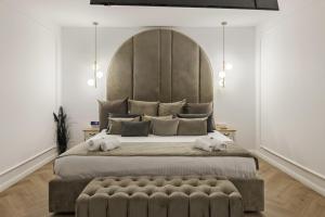 a bedroom with a large bed with a large headboard at Eden Central Boutique Suites - Garden & Spacious Apartments in Cluj-Napoca