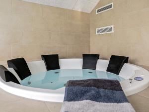 a round glass table with chairs in a bath tub at Luxury Pool Villa in Marielyst - By Traum Ferienwohnungen in Marielyst