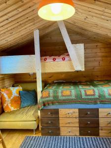 un letto a castello in una baita di tronchi con un divano di Forest Cabin Near Trillevallen Ski Resort a Trillevallen