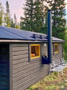 una piccola cabina con due sedie sedute all'esterno di Forest Cabin Near Trillevallen Ski Resort a Trillevallen