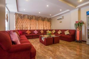 ein Wohnzimmer mit einem roten Sofa und einem Tisch in der Unterkunft Good Luck Day Hotel & Apartment in Phnom Penh
