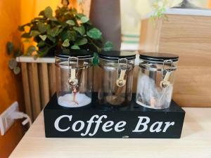 a coffee bar sign with three glass jars on a counter at OYO 1157 Kegama Residences 1 in Cavite