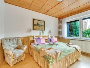a bedroom with a bed and a chair at Ferienwohnung im Herzen Ilsenburgs in Ilsenburg