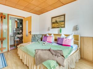 a bedroom with a large bed with colorful pillows at Ferienwohnung im Herzen Ilsenburgs in Ilsenburg