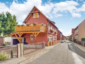 a red house with a balcony on a street at Ferienwohnung im Herzen Ilsenburgs in Ilsenburg +32 photos