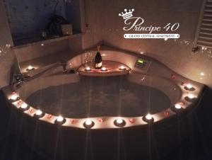a bath tub with a bottle of wine and lights at Bari Grand Central Apartment in Bari