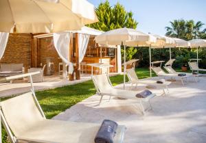 a group of chairs and umbrellas on a patio at Ostia Antica Park Hotel & Spa in Ostia Antica